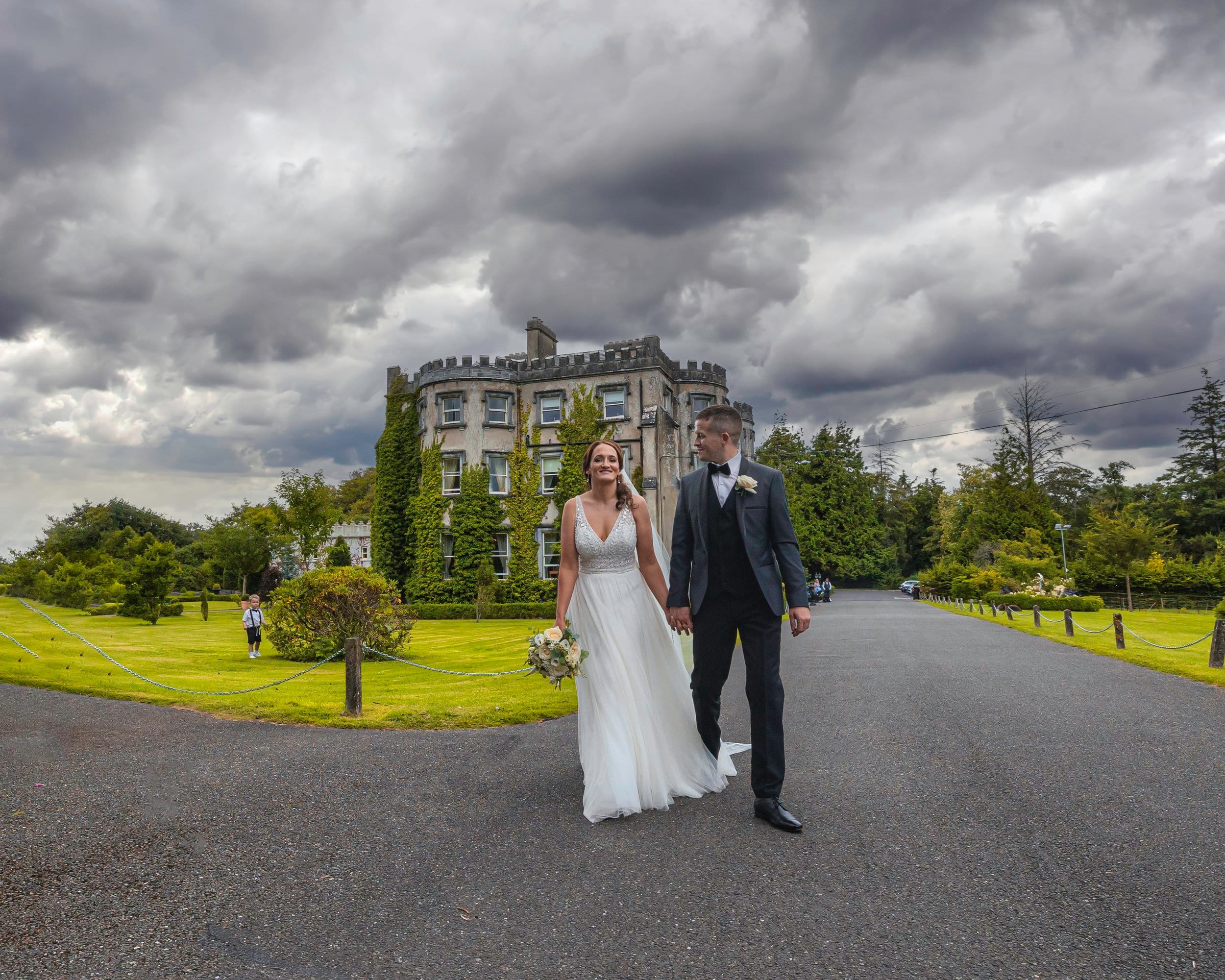 A couple walking hand-in-hand in a lush garden in Kerry