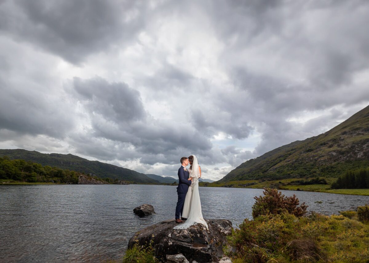 Bride and groom laughing together in front of the misty cliffs of Dingle, Kerry, JOD'Photography
