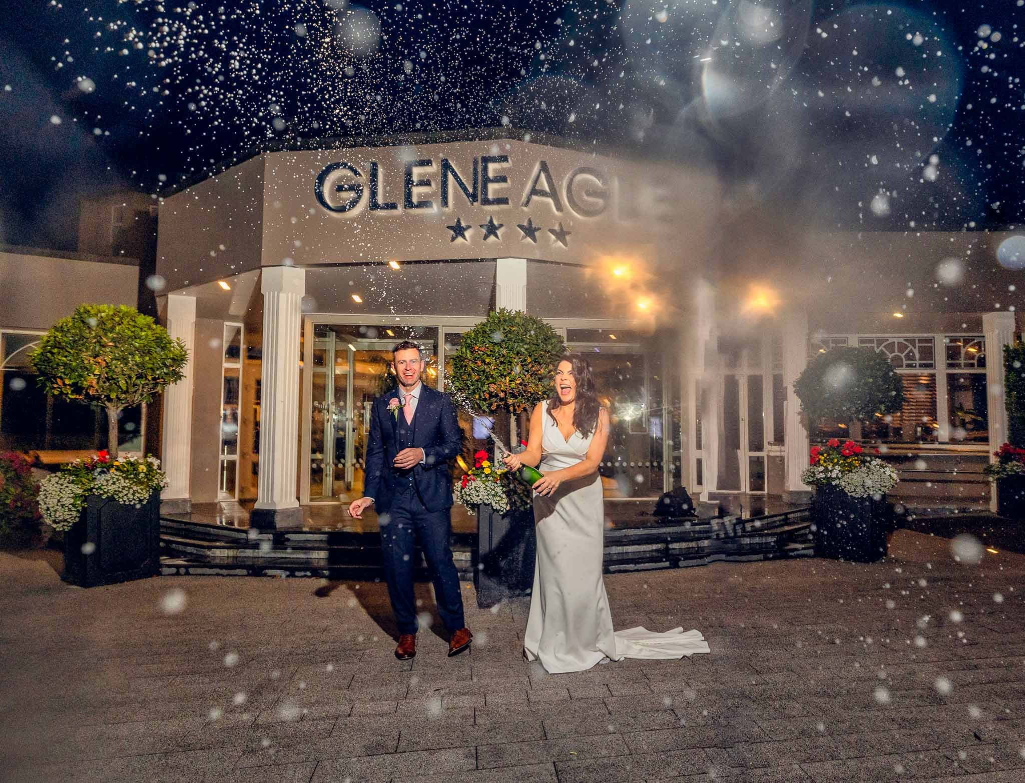 Bride and groom spraying champagne outside the Glen Eagle hotel Kerry-JOD'Photography