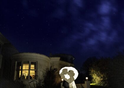 Creative portrait of bride and groom holding an umbrella while i light them from behind using a Godox flash to cast their silhouettes onto the umbrella at a Cork wedding venue