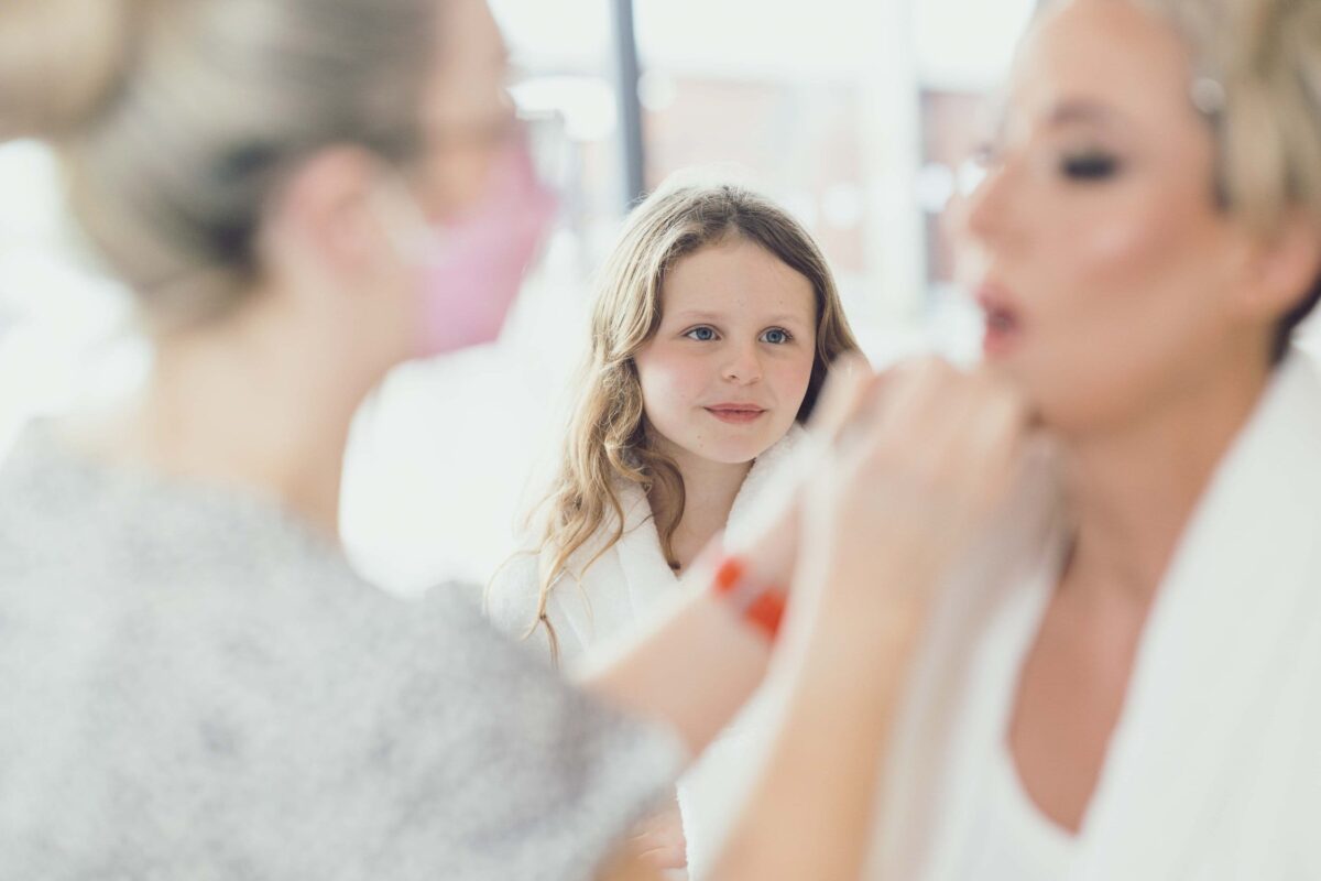 Daughter of the bride Gazes on as her mother the bride is having her makeup done in West Cork