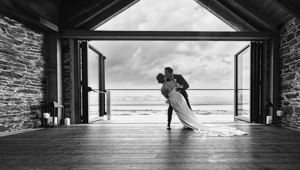 Bride and groom walking through a field in Cork with dramatic skies, JOD'Photography