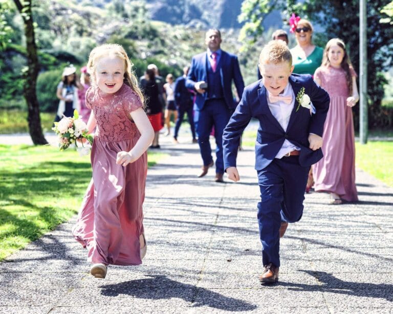 Flower girl and page boy racing along the path at Gougane Barra, West Cork