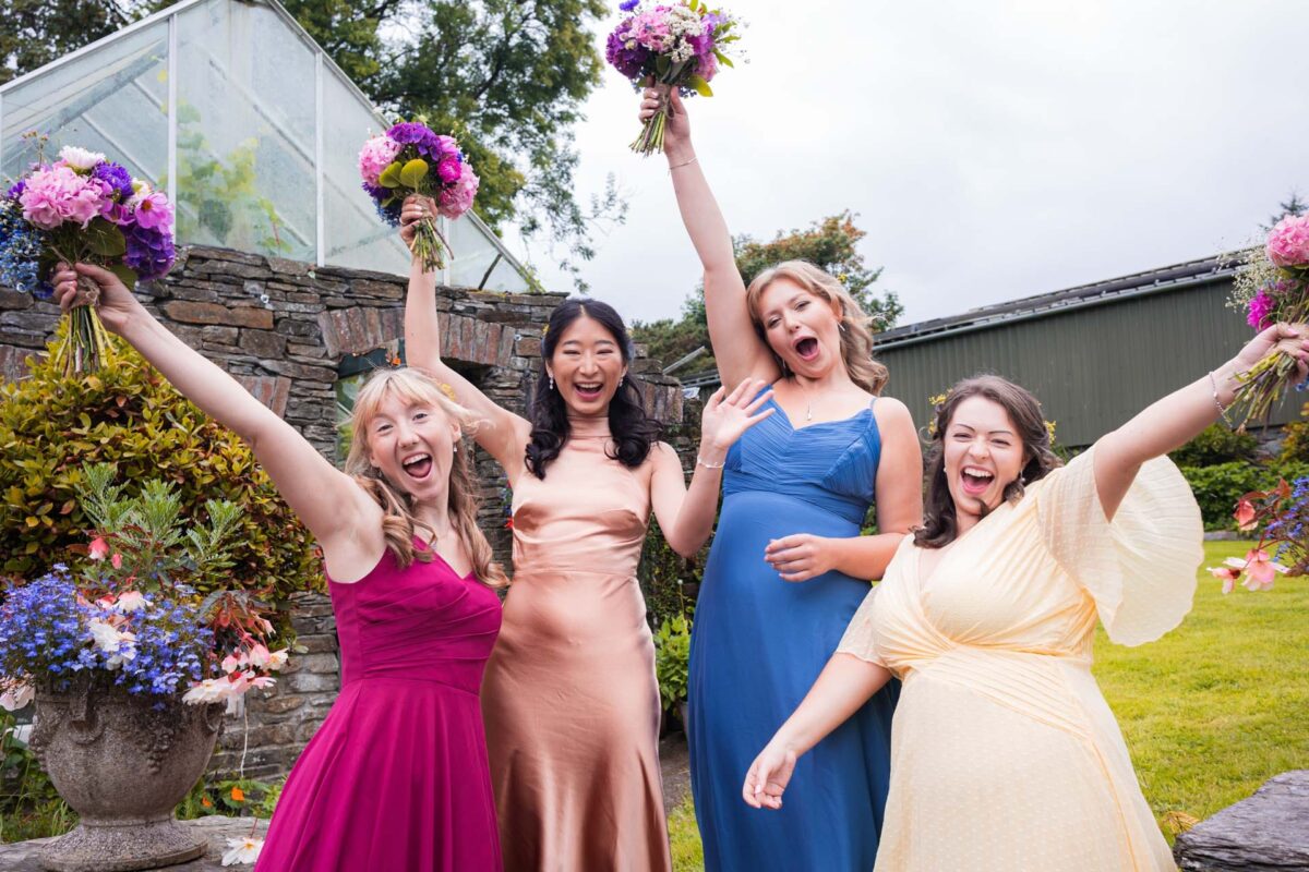 Fun Loving bridal party cheering and raising the wedding flowers in West Cork