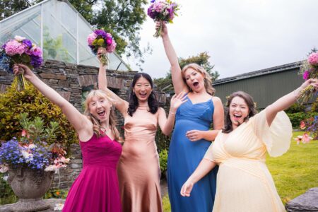 Fun Loving bridal party cheering and raising the wedding flowers in West Cork