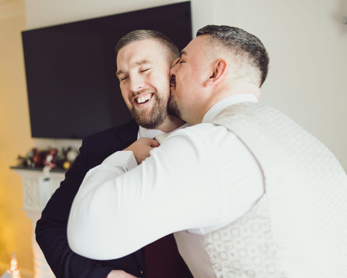 Groom and groomsmen laughing by the lush green hills of Dingle, Kerry, JOD'Photography