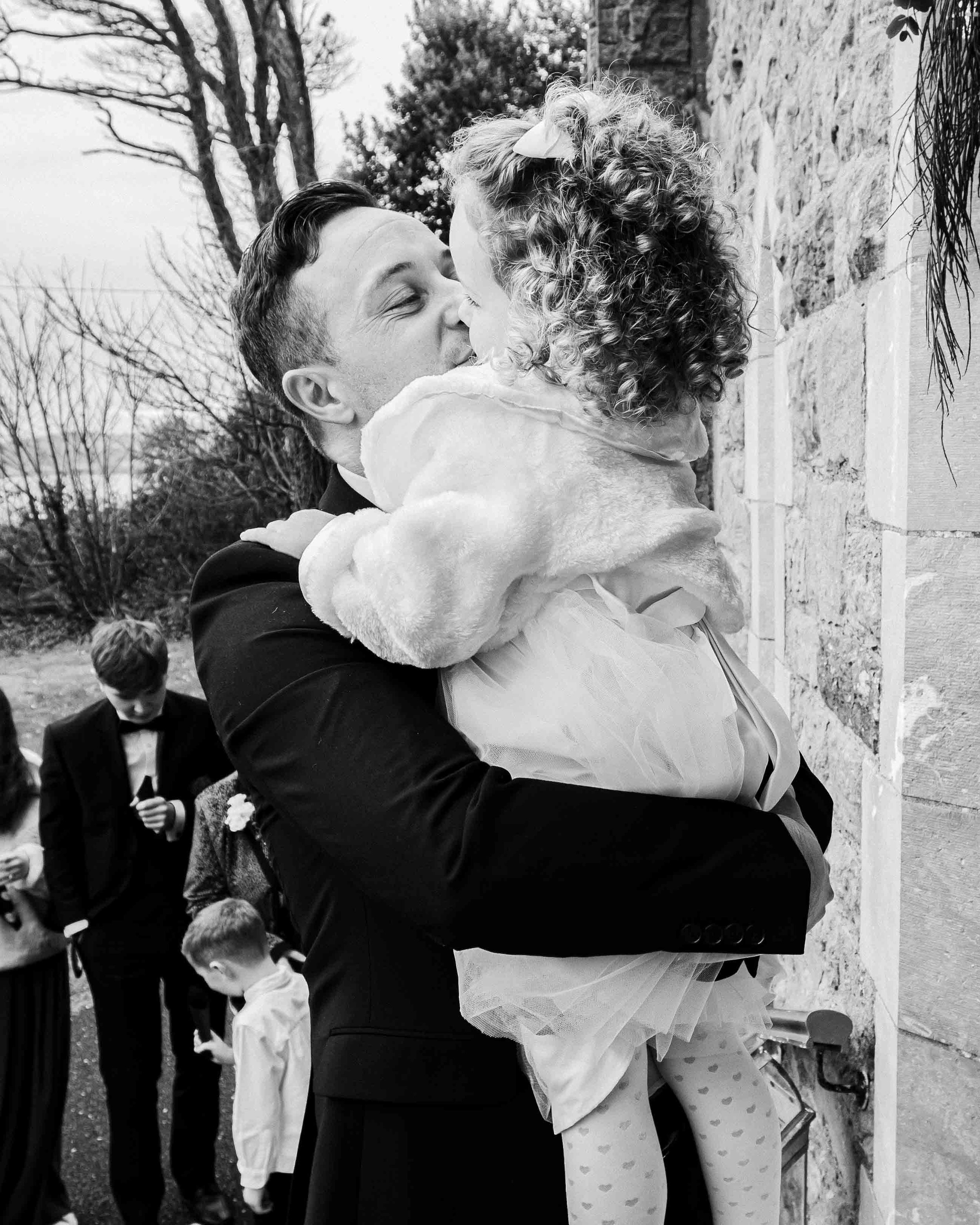 Groom kissing his daughter outside a Kerry Church on Valentia Island Ireland