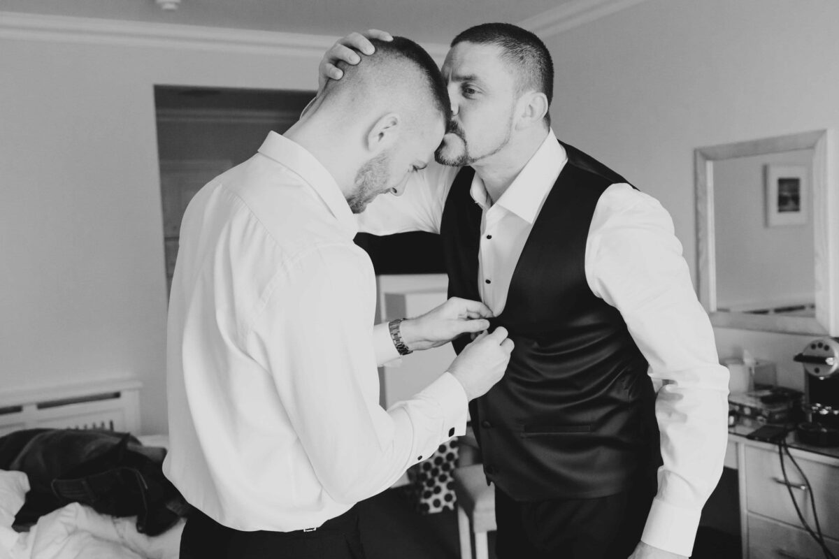 Groom kissing his son on the head as they get dressed for the wedding in Dunmore House Hotel West Cork