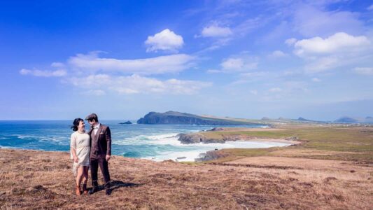 Bride and groom walking along a coastal cliff during wedding day