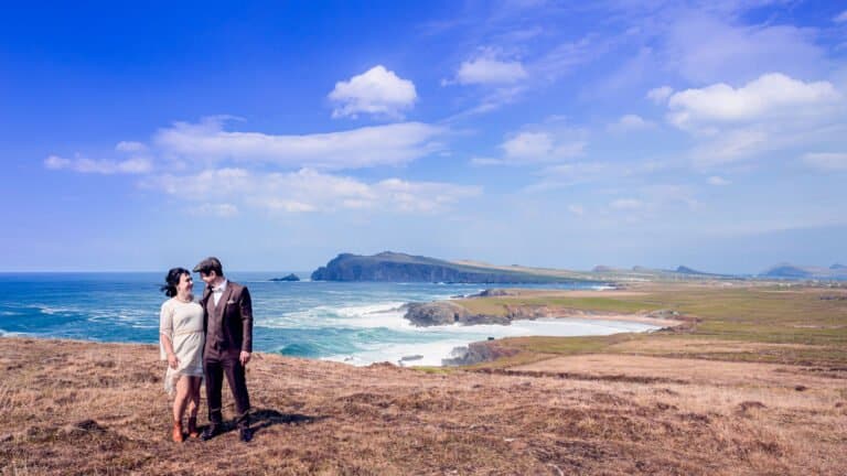 Bride and groom walking along a coastal cliff during wedding day