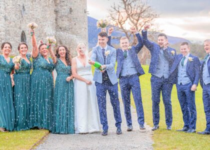 Groom shakes and sprays champagne everywhere at Ross castle in Killarney Co Kerry as bridal party cheer and raise their hands