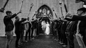 Guard of honour at Kilmichael church in cork as the bride and groom walk under the hurleys