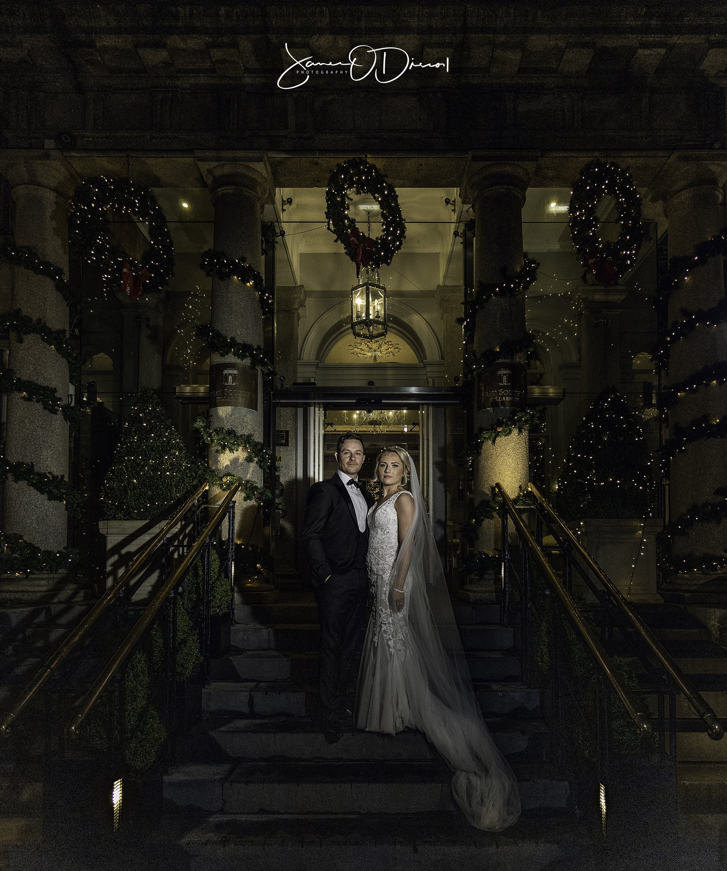 Bride and groom sharing a kiss at Christmas Outside the Great Southern Hotel in Killarney