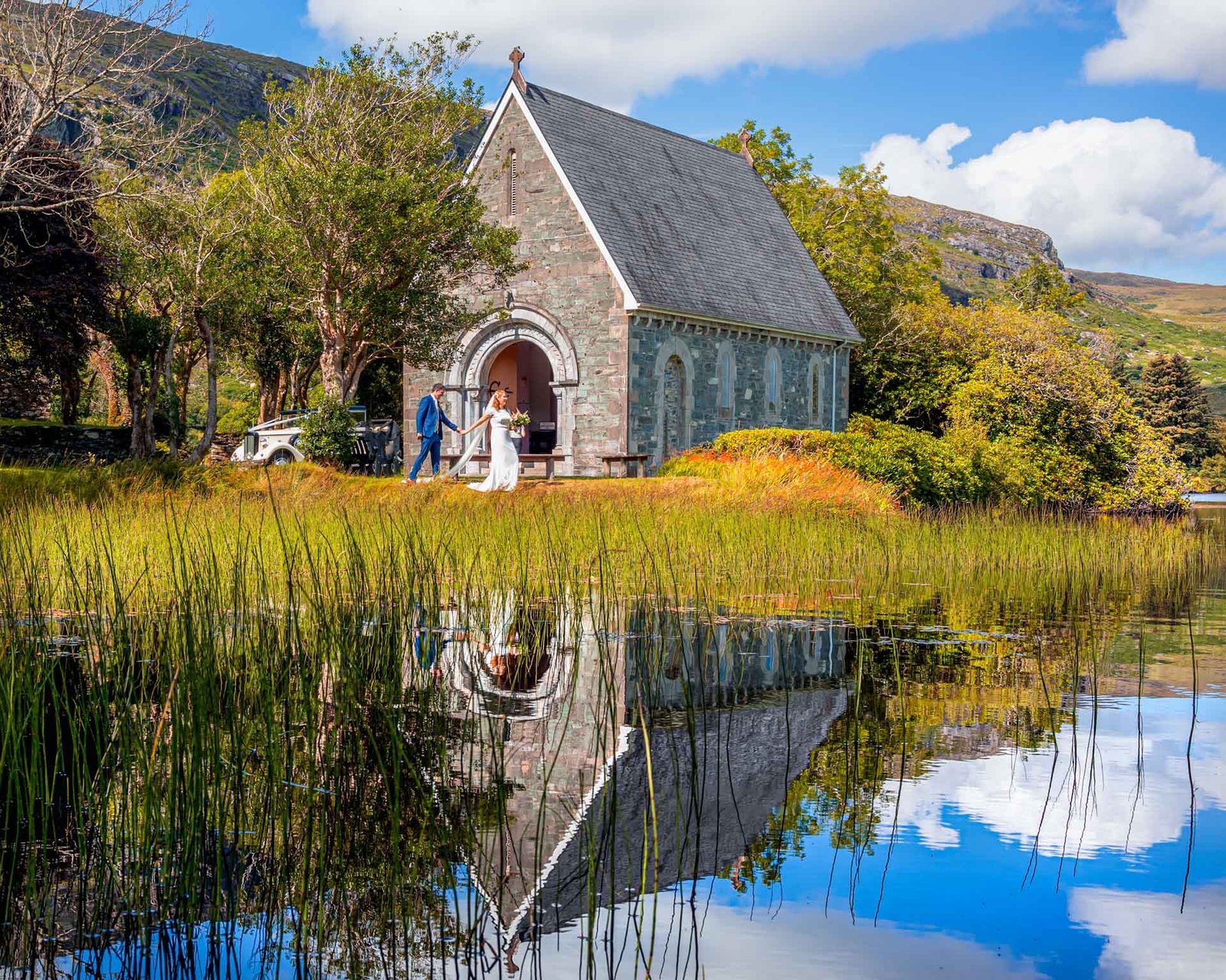 Bride and Groom walking hand in hand into Gougane Barra church west Cork Ireland