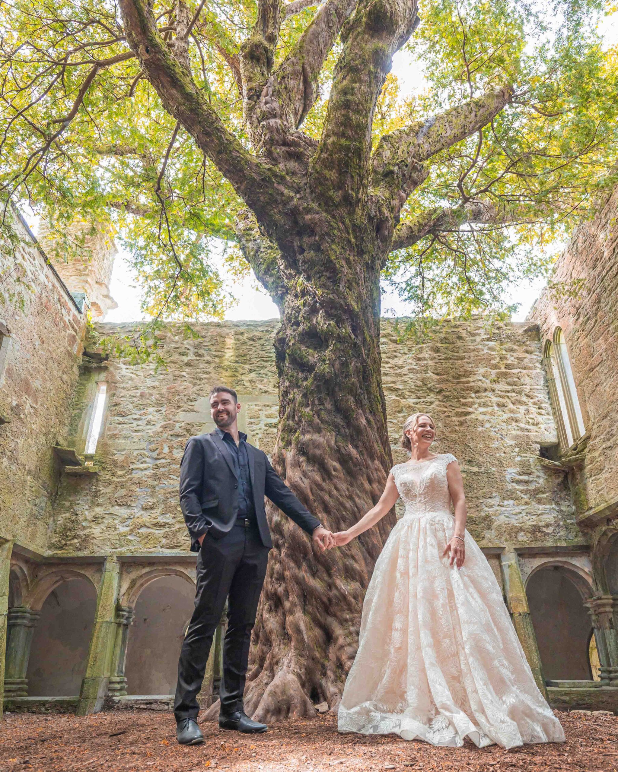 Wide shot of Muckross Abbey with wedding party – JOD'Photography