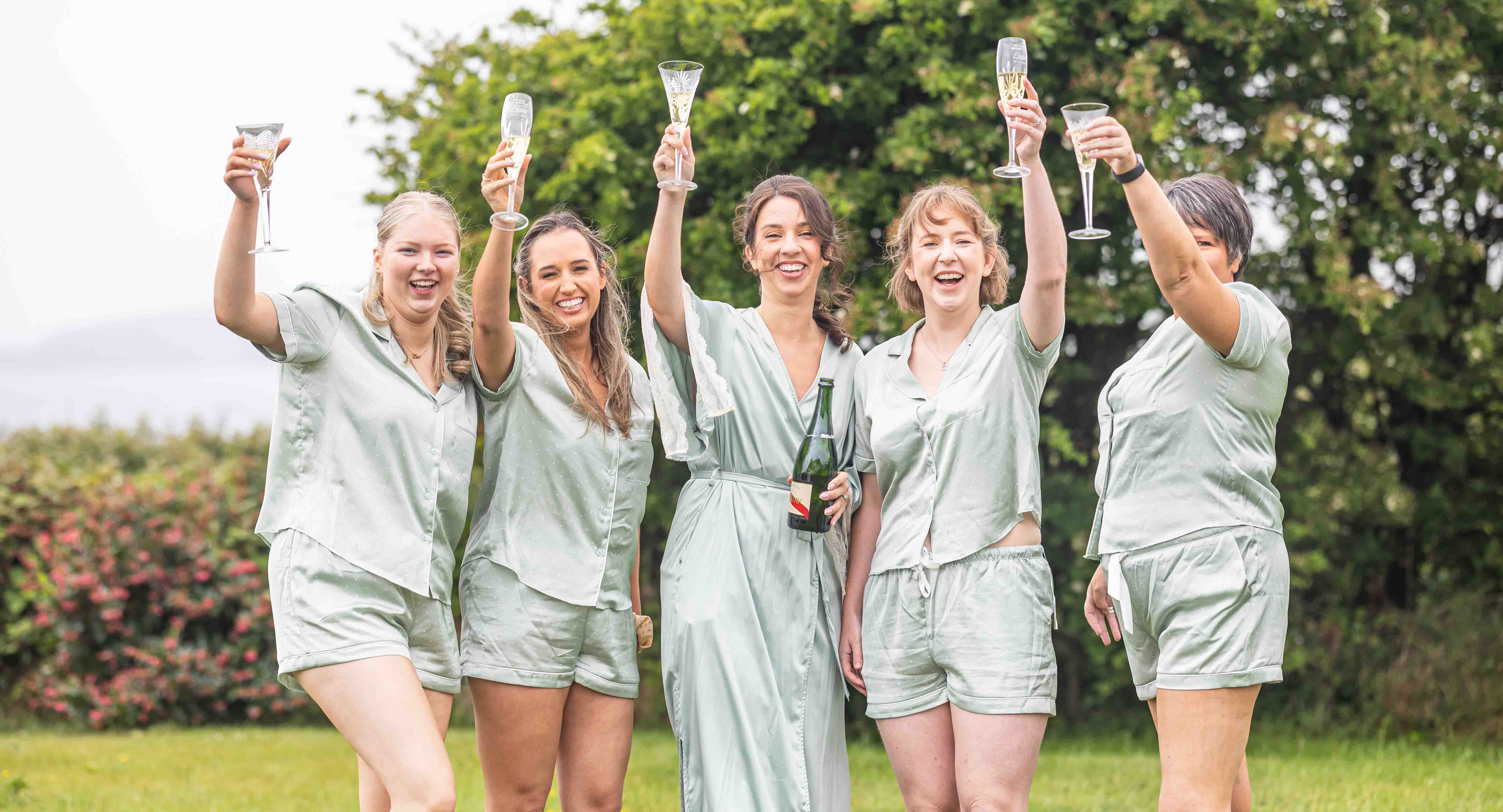 Bridesmaids laughing during champagne spray – JOD'Photography