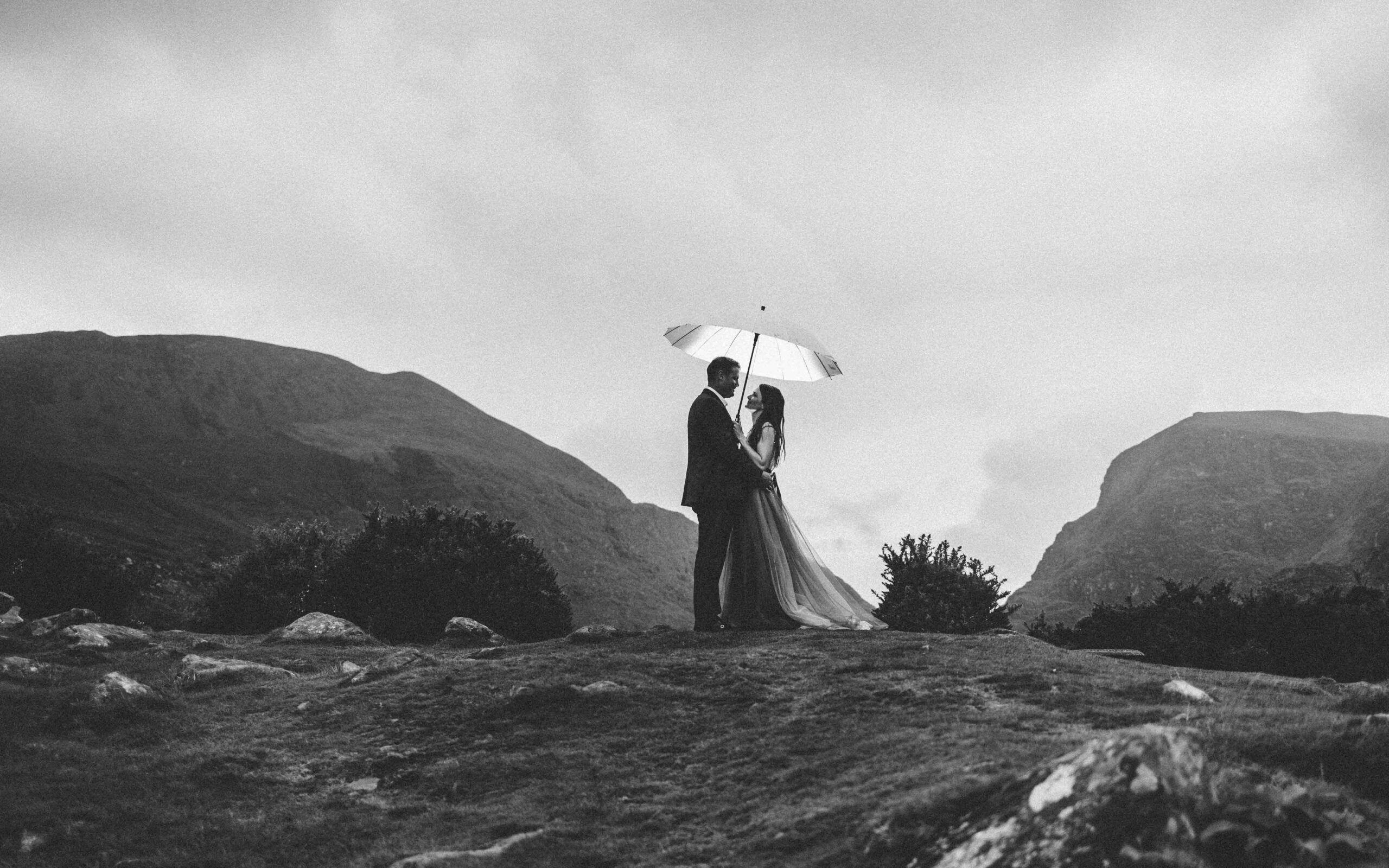 the rugged mountain road winding through the Gap of Dunloe with the couple in view JODPhotography