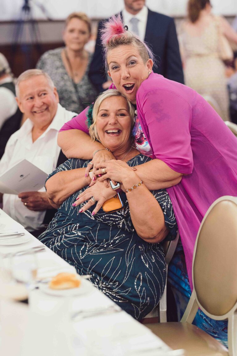 Guests laughing and hugging around the wedding breakfast table at The Brehon Hotel, Killarney