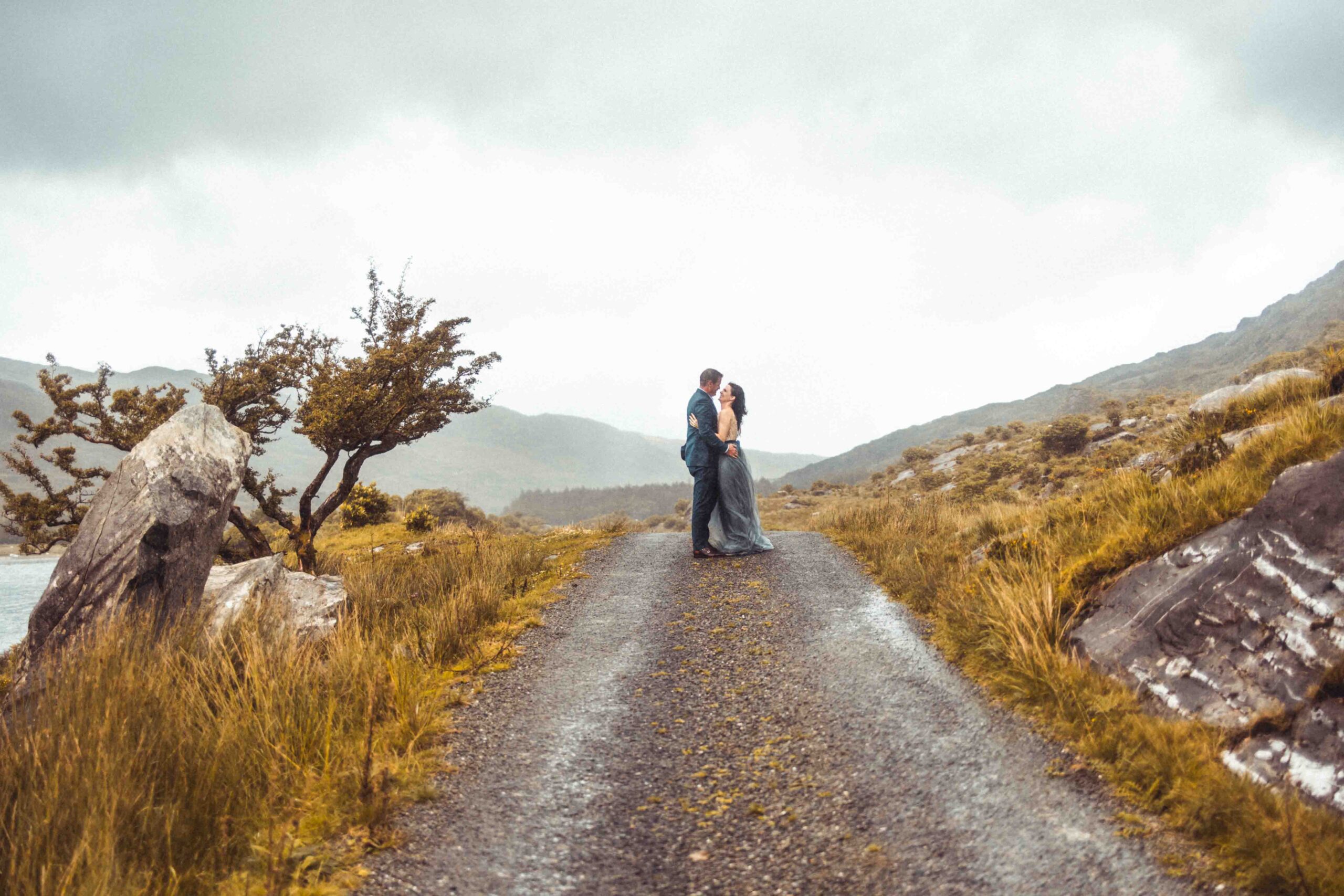 the rugged mountain road winding through the Gap of Dunloe with the couple in view JODPhotography