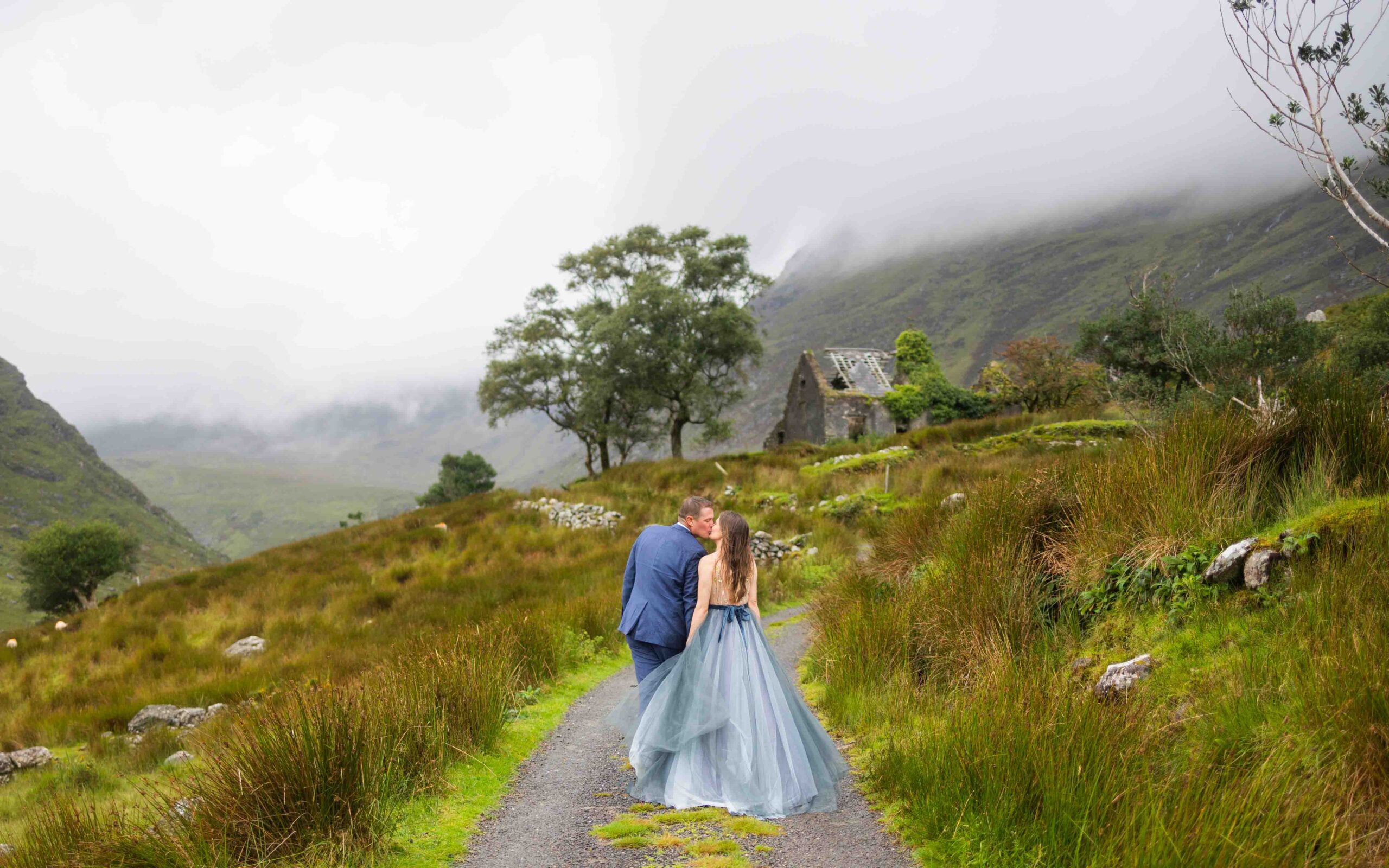 Matt and Heather running across wet road as weather clears in Kerry mountains JODPhotography
