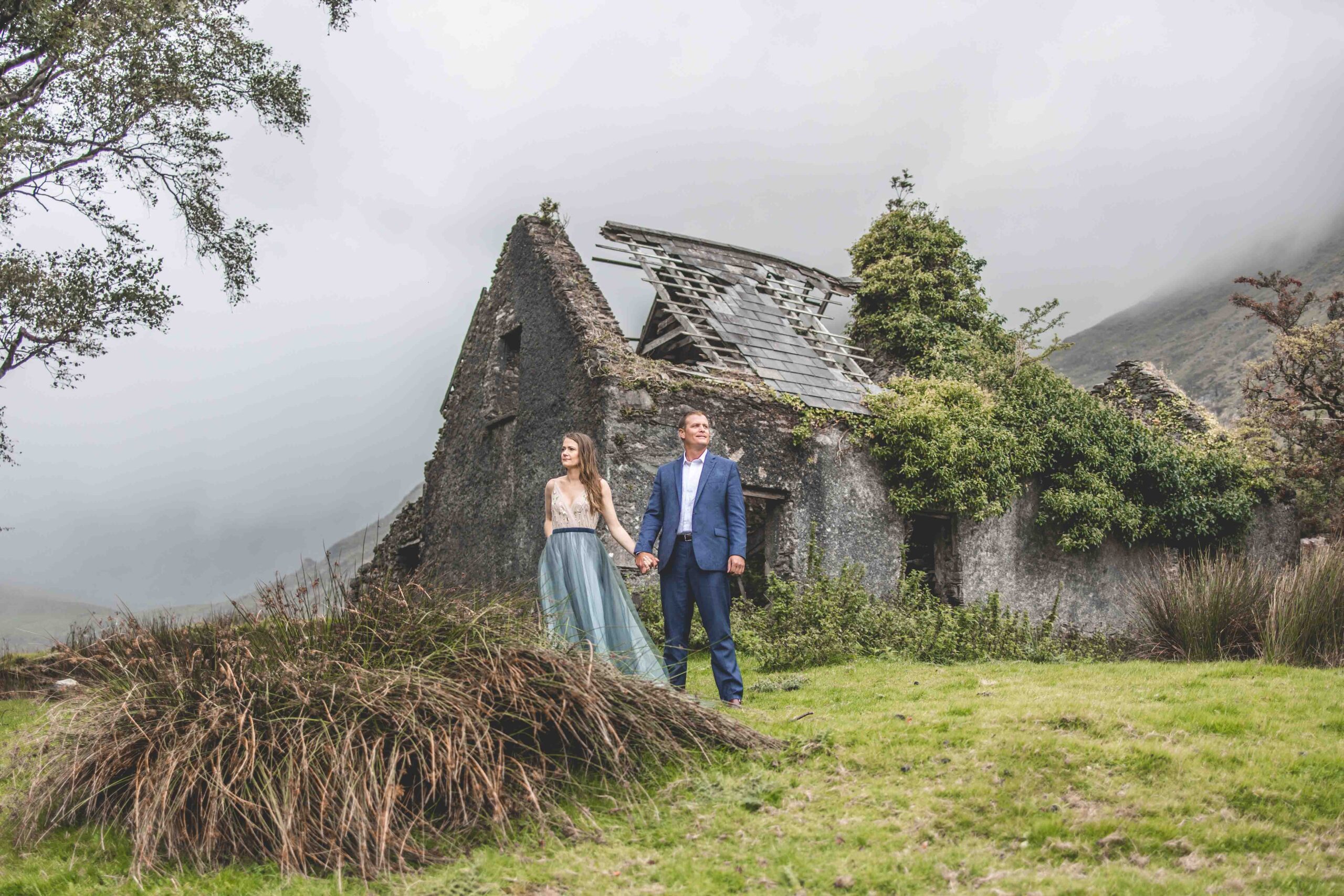 rocky old slate house with rugged backdrop of the Black Valley behind the couple JODPhotography