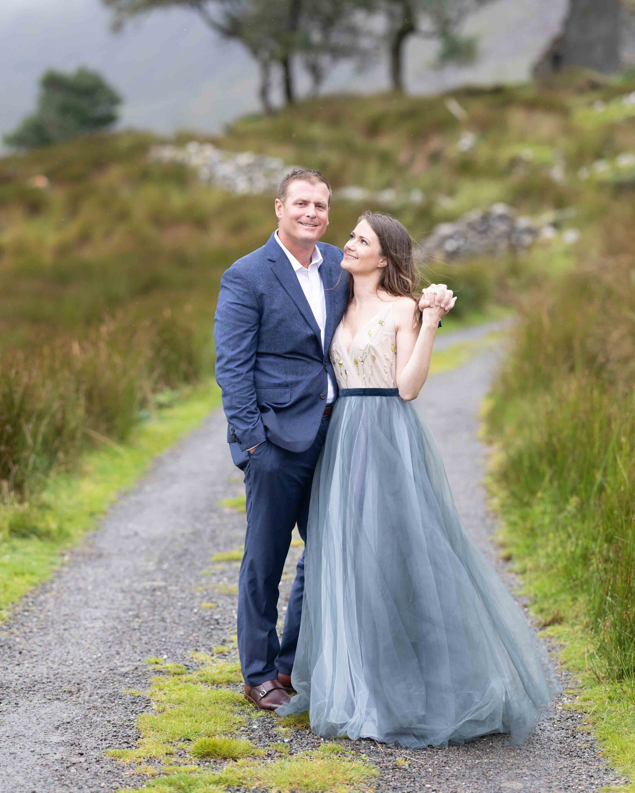 intimate portrait of Matt and Heather laughing under the Irish rain by Black Valley walls JODPhotography