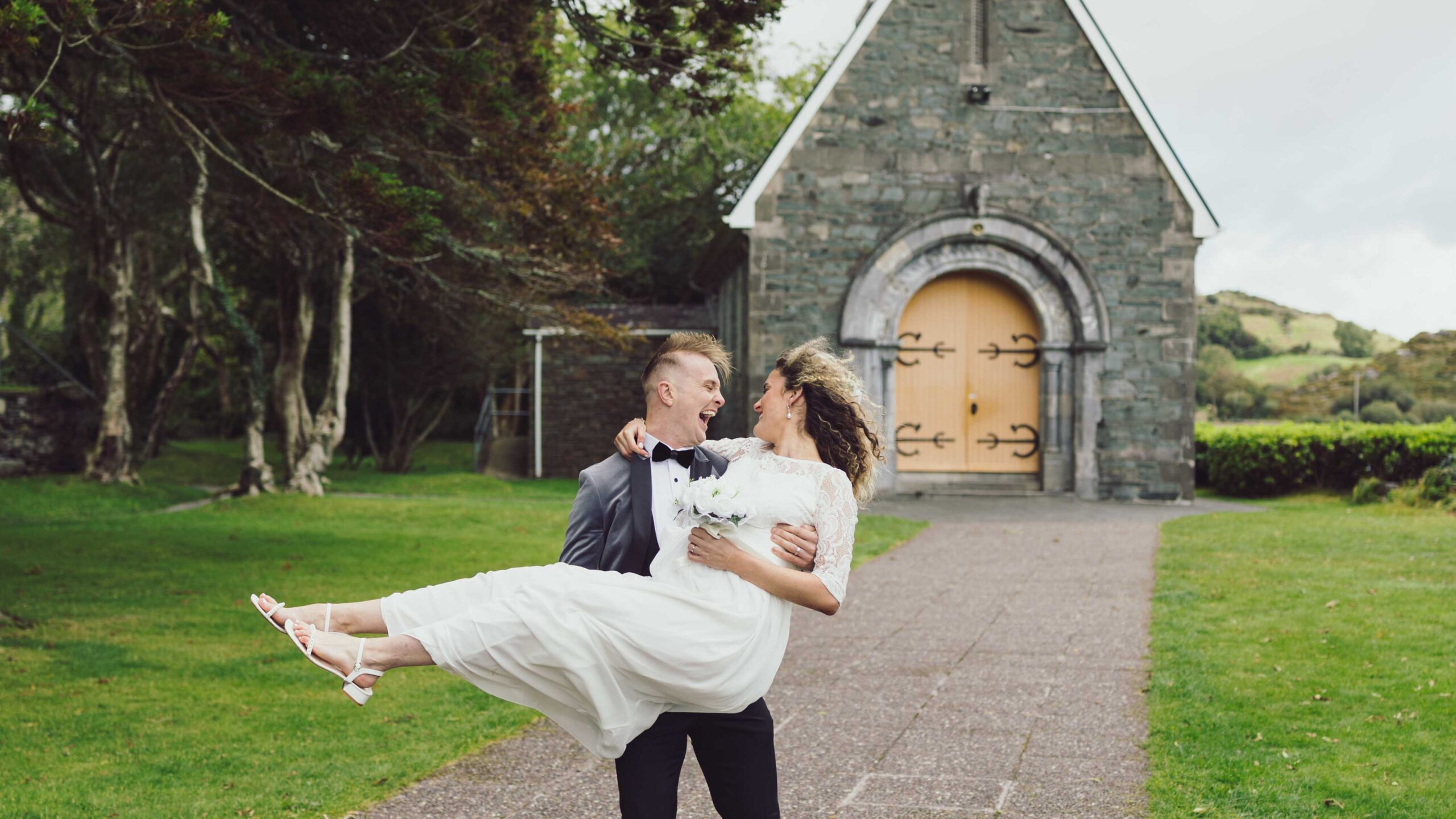 Bride and groom walking towards Gougane Barra chapel — JOD Photography