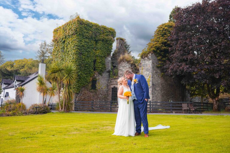 Bride and groom outside the ivy-covered ruins at Vienna Woods Hotel, Co. Cork