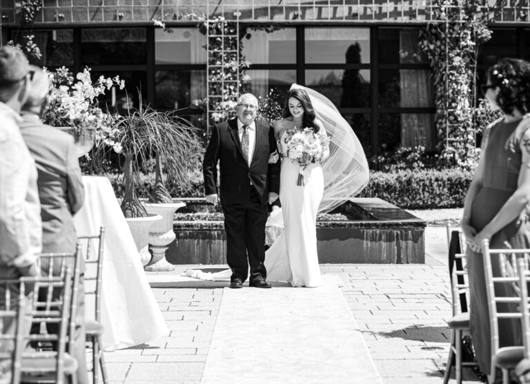 Black and white photo of the bride walking down the garden aisle with her father, Co. Clare