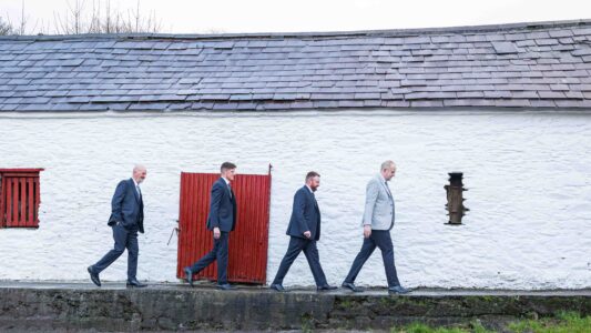 Groom laughing with groomsmen during morning prep at home — JOD Photography