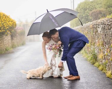 Bride and groom beside Tramore coastline in rain