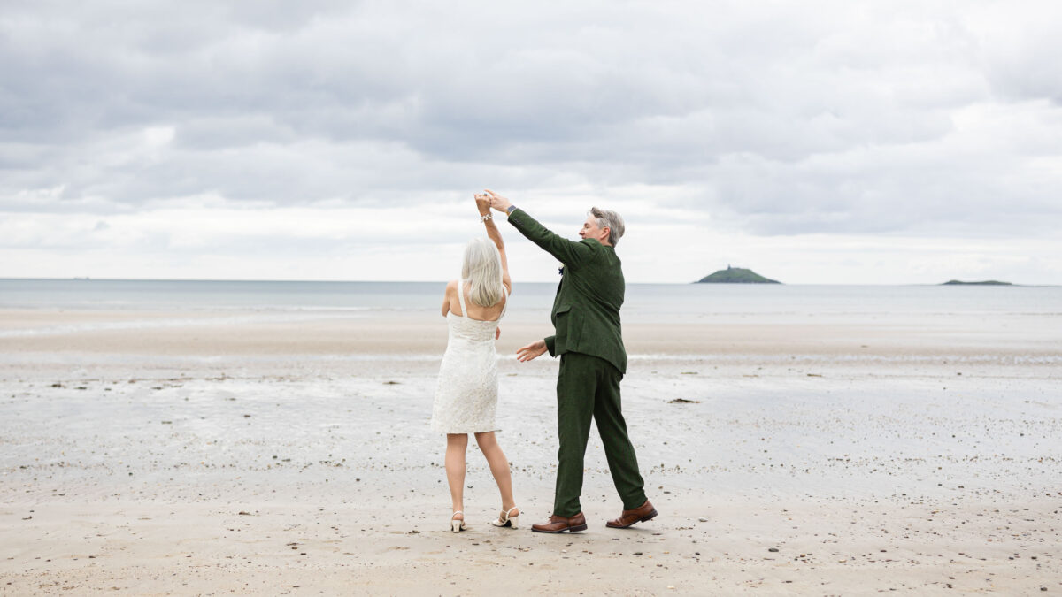 Couple walking along Garryvoe beach after vow renewal