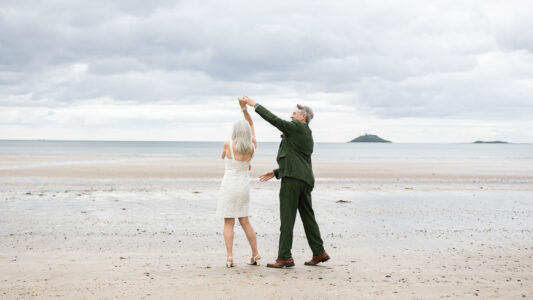 Couple walking along Garryvoe beach after vow renewal