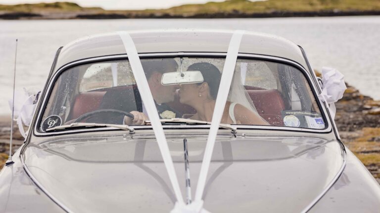 Bride and groom embracing beside Kerry pier – JOD Photography
