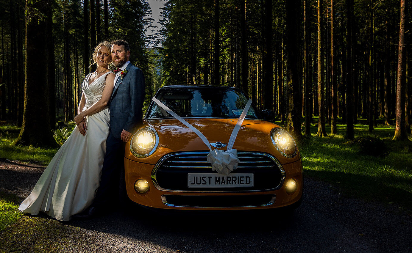 Bride and groom beside a yellow Mini Cooper in the forests near Gougane Barra photographed by JOD Photography