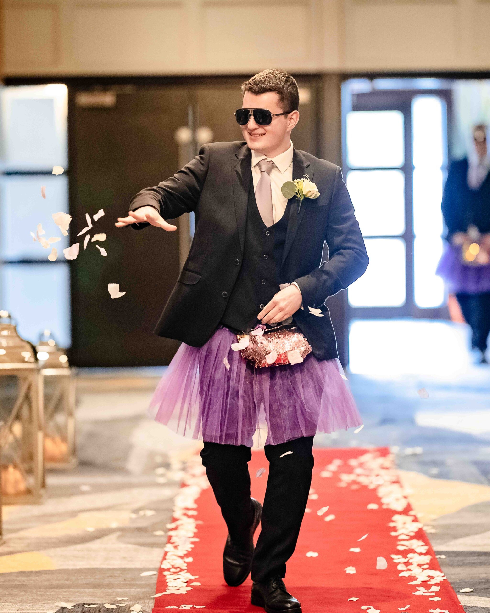 Flower dudes wearing purple tutus at wedding ceremony