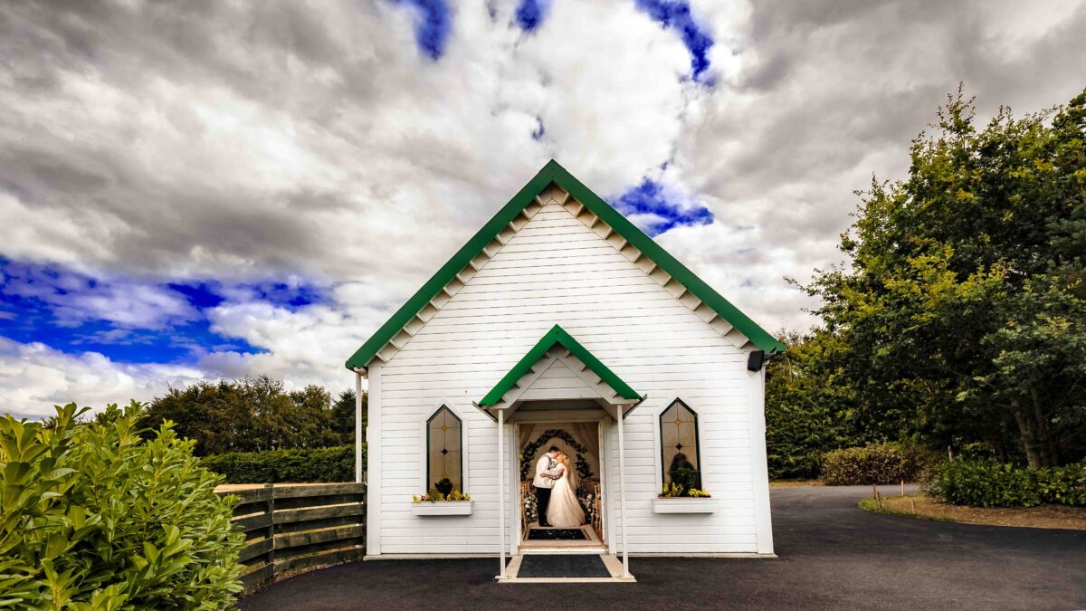 Bride and groom at the white wedding chapel at Clanard Court Hotel