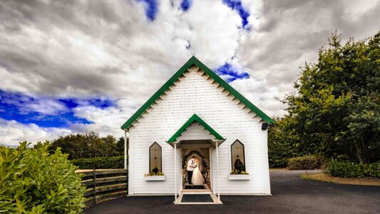 Bride and groom at the white wedding chapel at Clanard Court Hotel