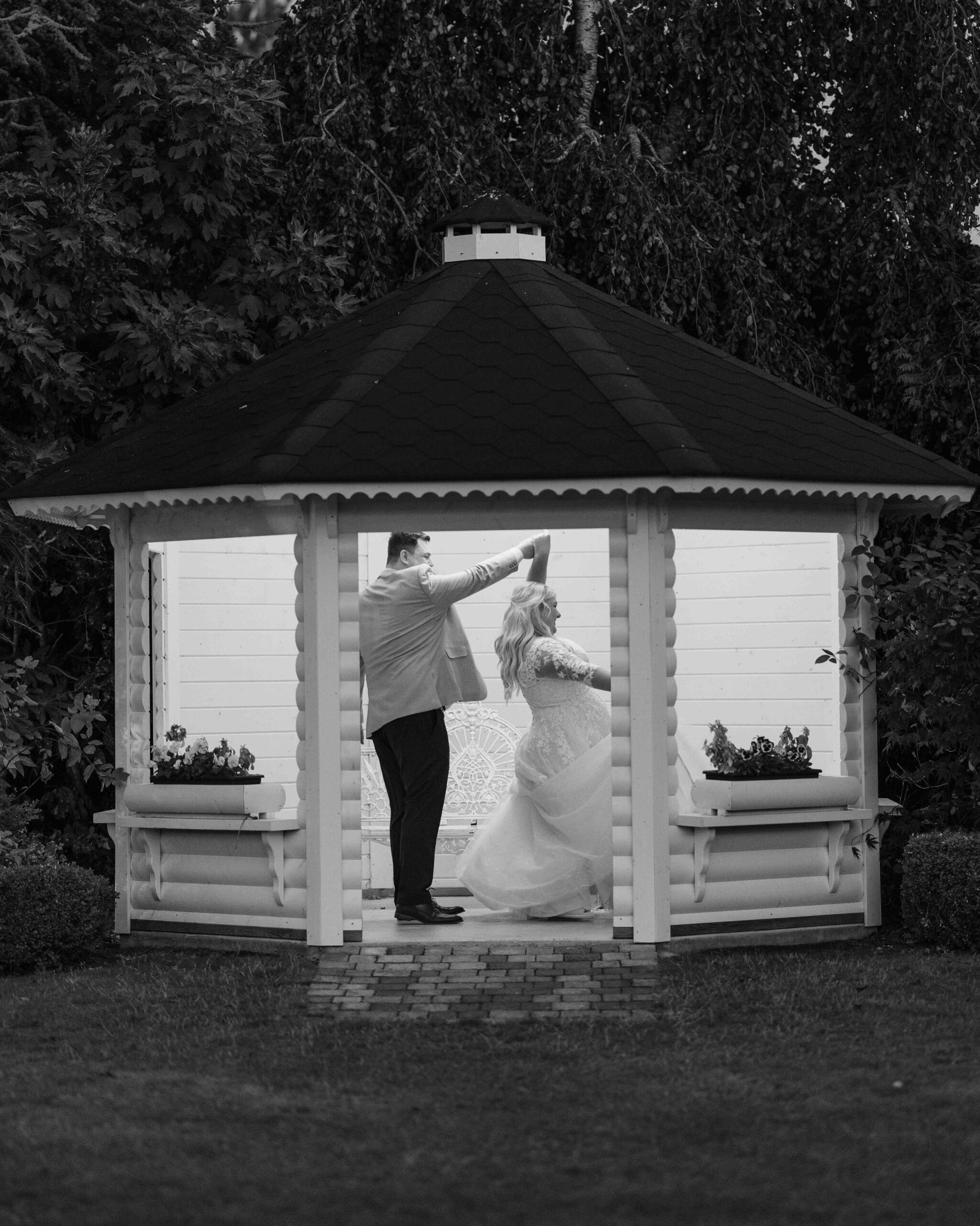 Caitlin and Jason laughing with their wedding party in the hotel gardens