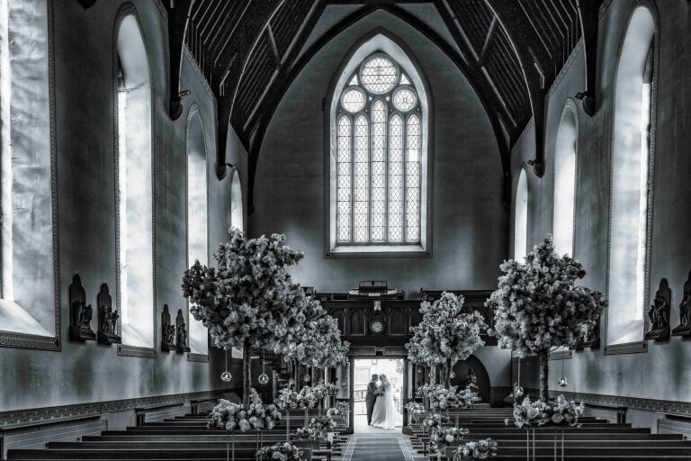 Black and white photo of a bride and groom at the end of the chapel aisle at Hotel Woodstock, Co. Clare