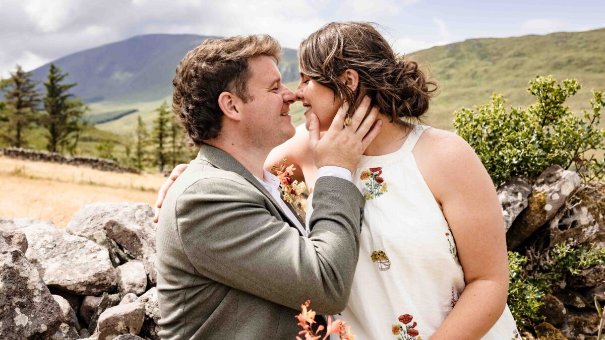 Aíne and Ciarán kissing beside an old stone wall in the Kerry countryside
