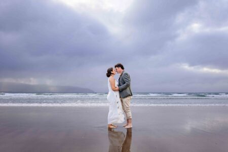 Aíne and Ciarán kissing beside the Atlantic Ocean on their wedding day