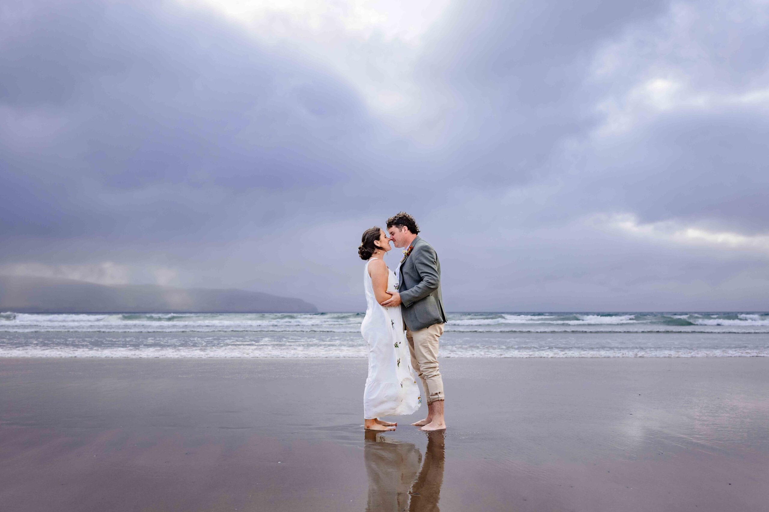 Aíne and Ciarán kissing beside the Atlantic Ocean on their wedding day