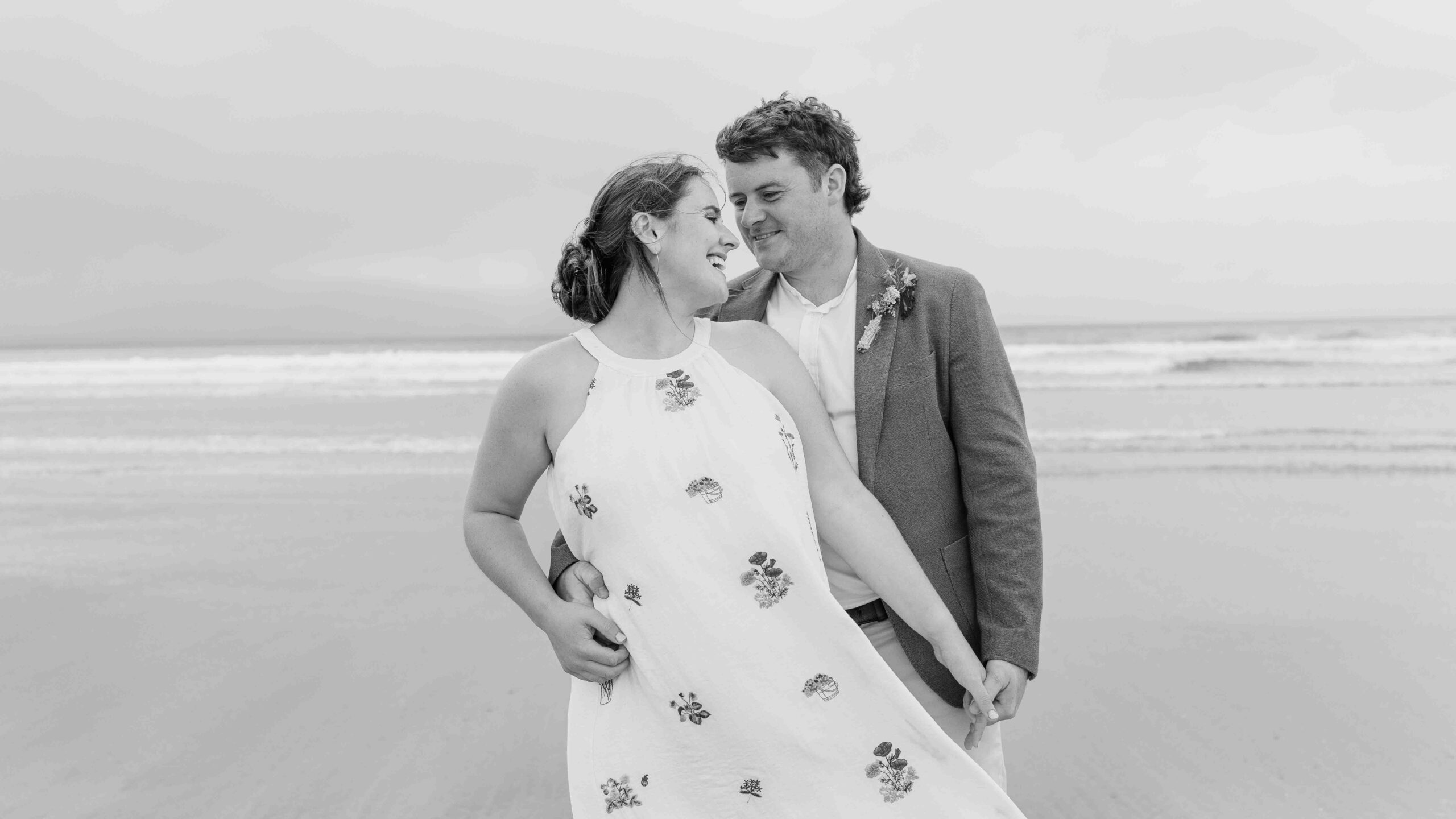 Wide wedding portrait beneath a dramatic sky on a West Kerry beach | JOD Photography