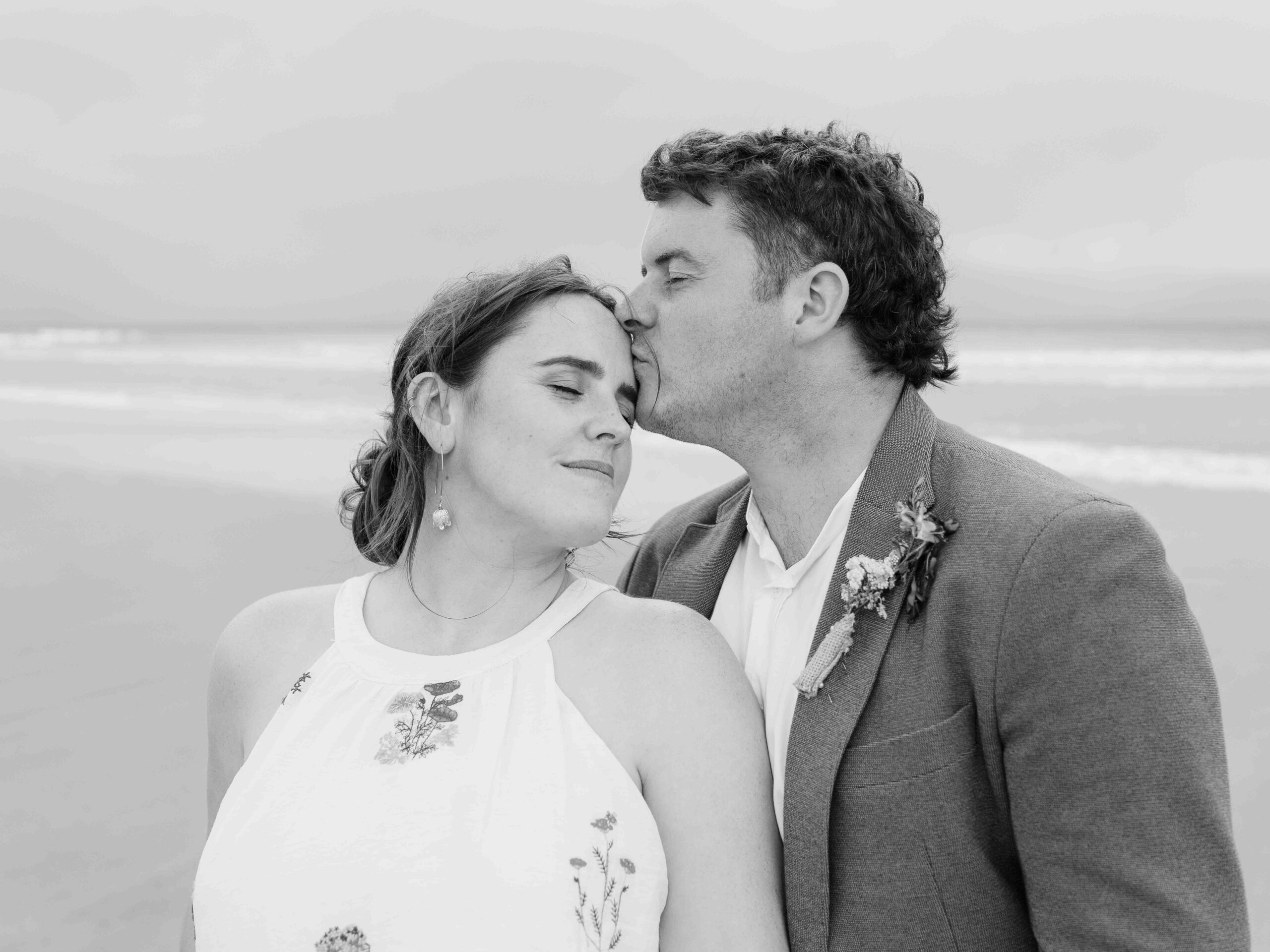 Aíne and Ciarán reflected in the wet sand beside the Atlantic Ocean