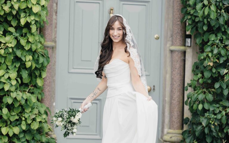 Bride smiling by the door at Ballyvolane House, County Cork