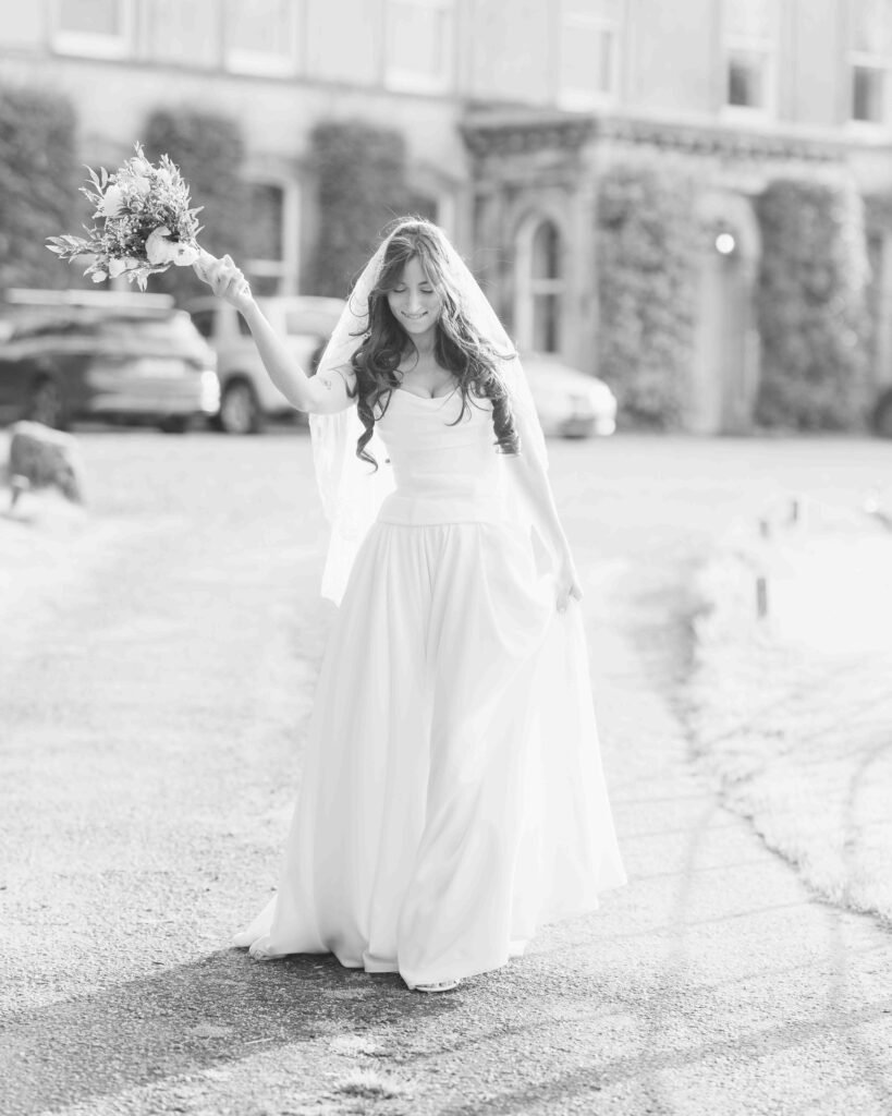 Bride laughing in her veil outside Ballyvolane House, County Cork