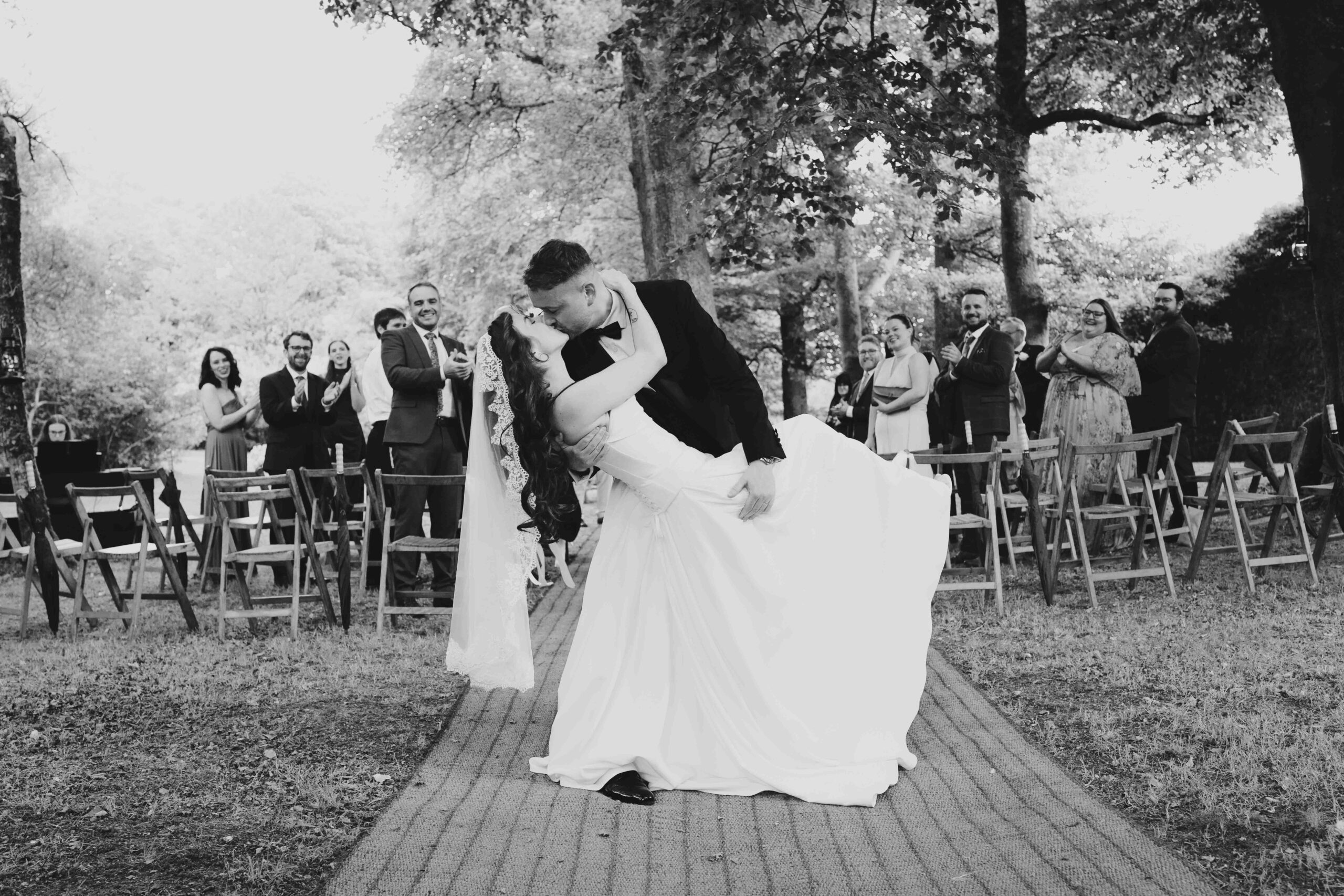 Bride and groom surrounded by family and friends during their woodland ceremony – JOD Photography