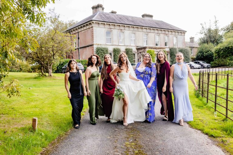Bridesmaids and bride walking along the driveway at Ballyvolane House, County Cork