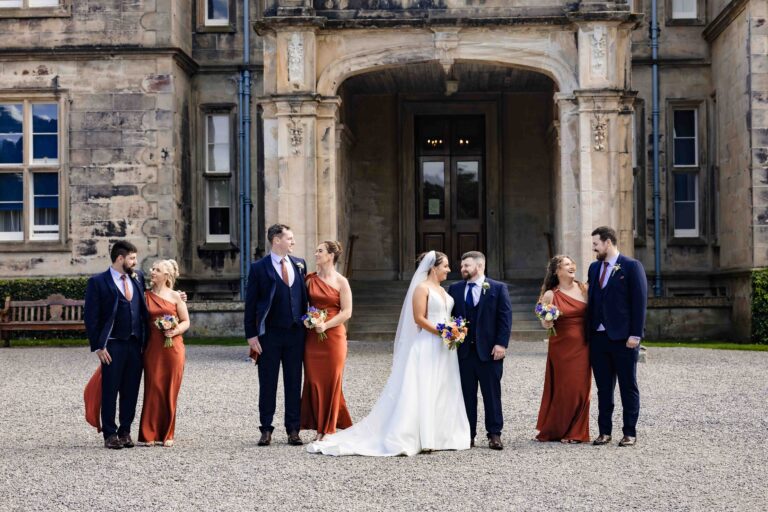 Bride and groom with bridesmaids and groomsmen at the entrance of Muckross House, Killarney